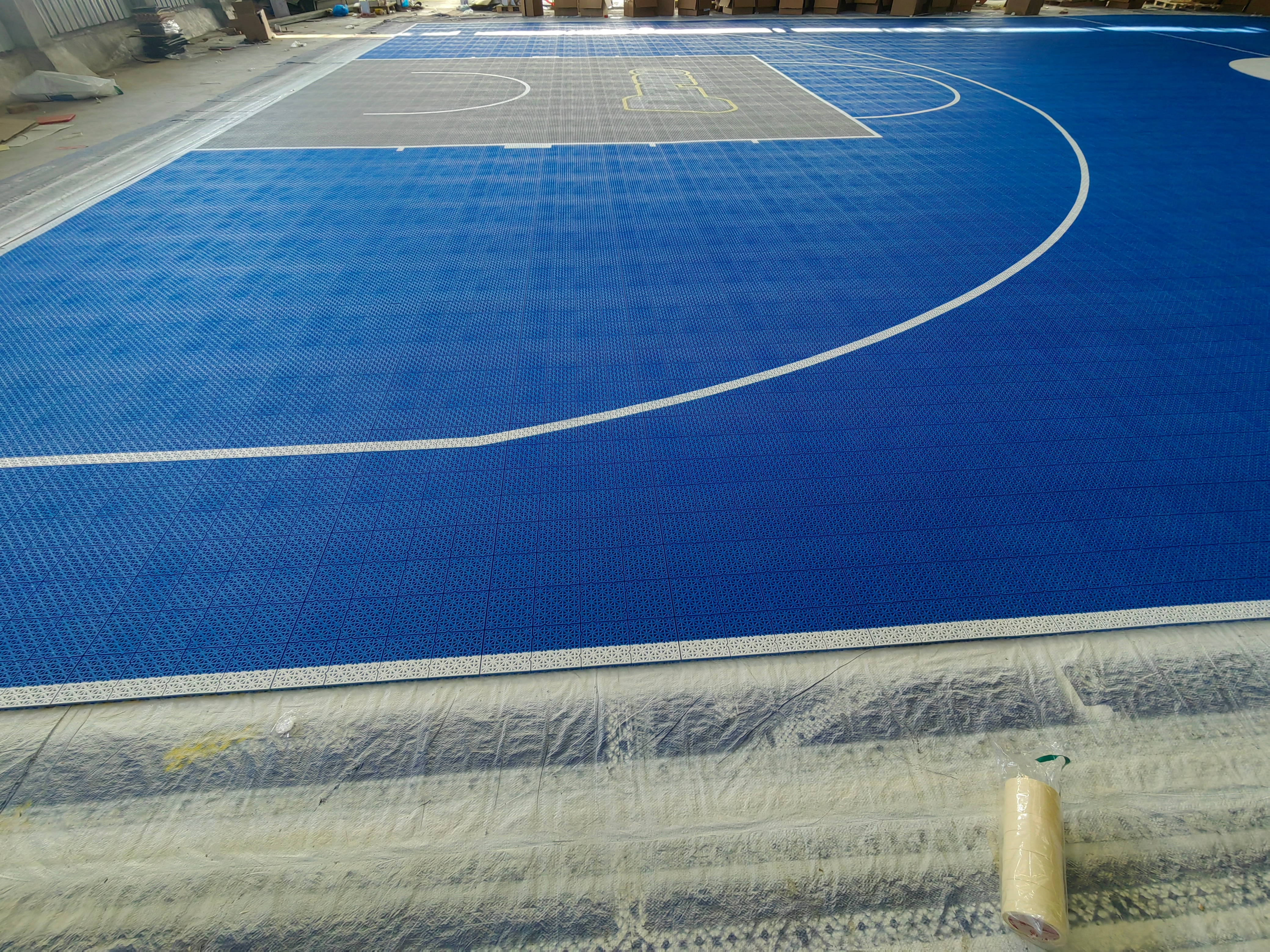 Blue court surface, white arc, and gray branded key before installation