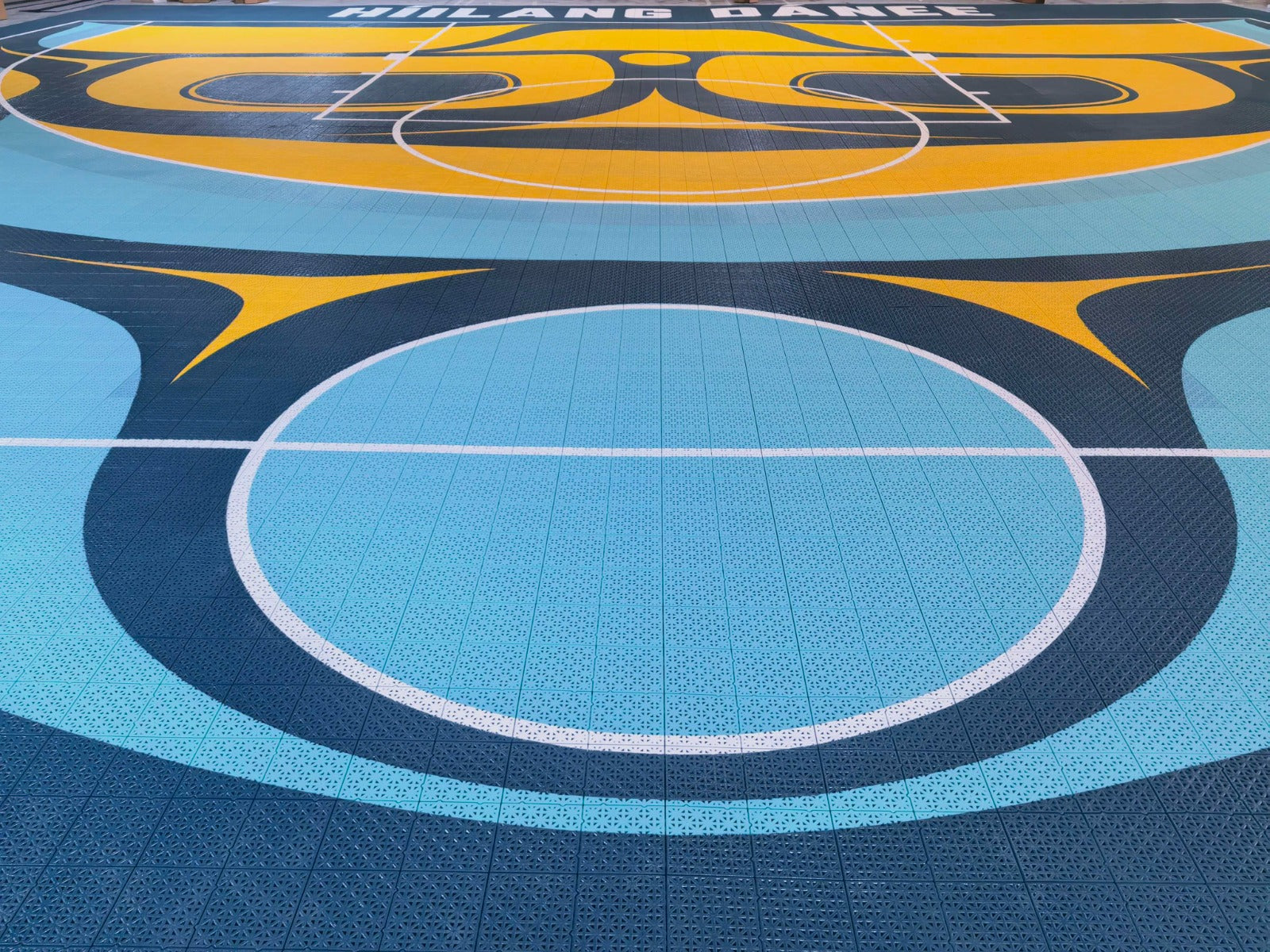 Turquoise center circle and Híílang Dánee lettering on the custom court