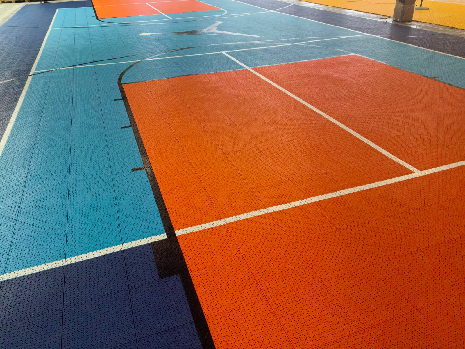 Warehouse view across the turquoise and orange Jumpman multi-sport court