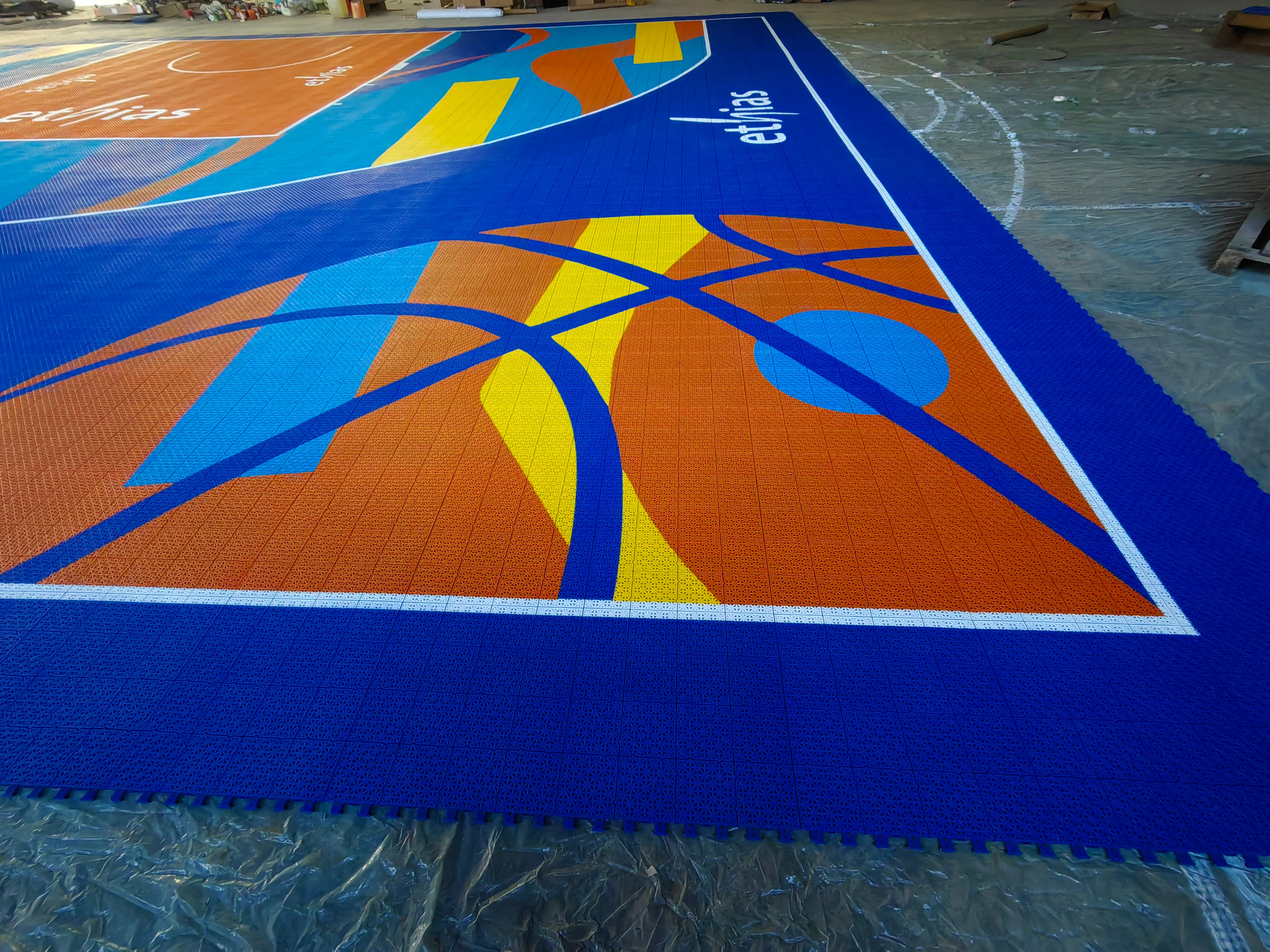 Custom basketball graphic and branded blue border on the Ethias court