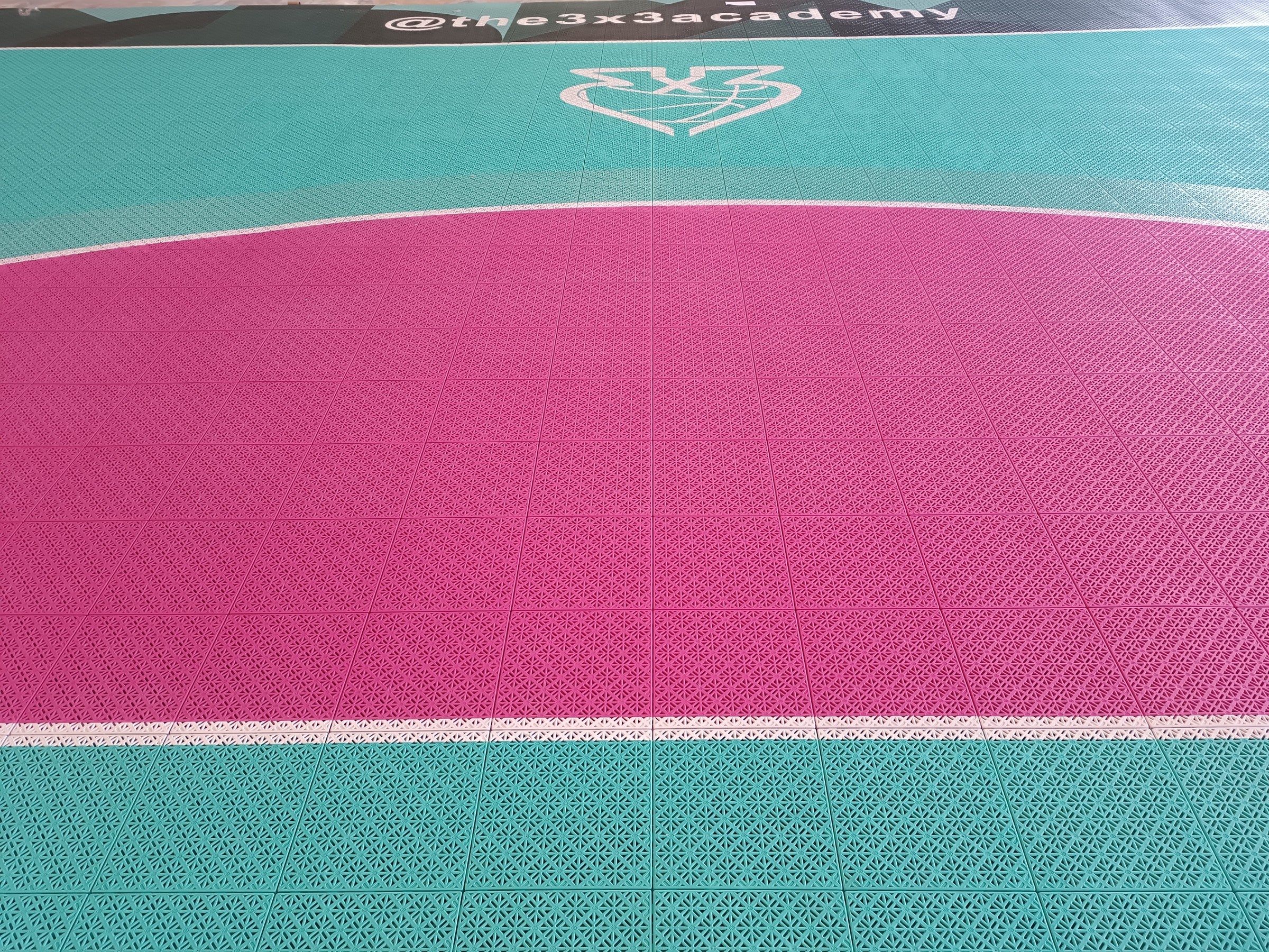 Turquoise and magenta tile surface with The 3x3 Academy branding