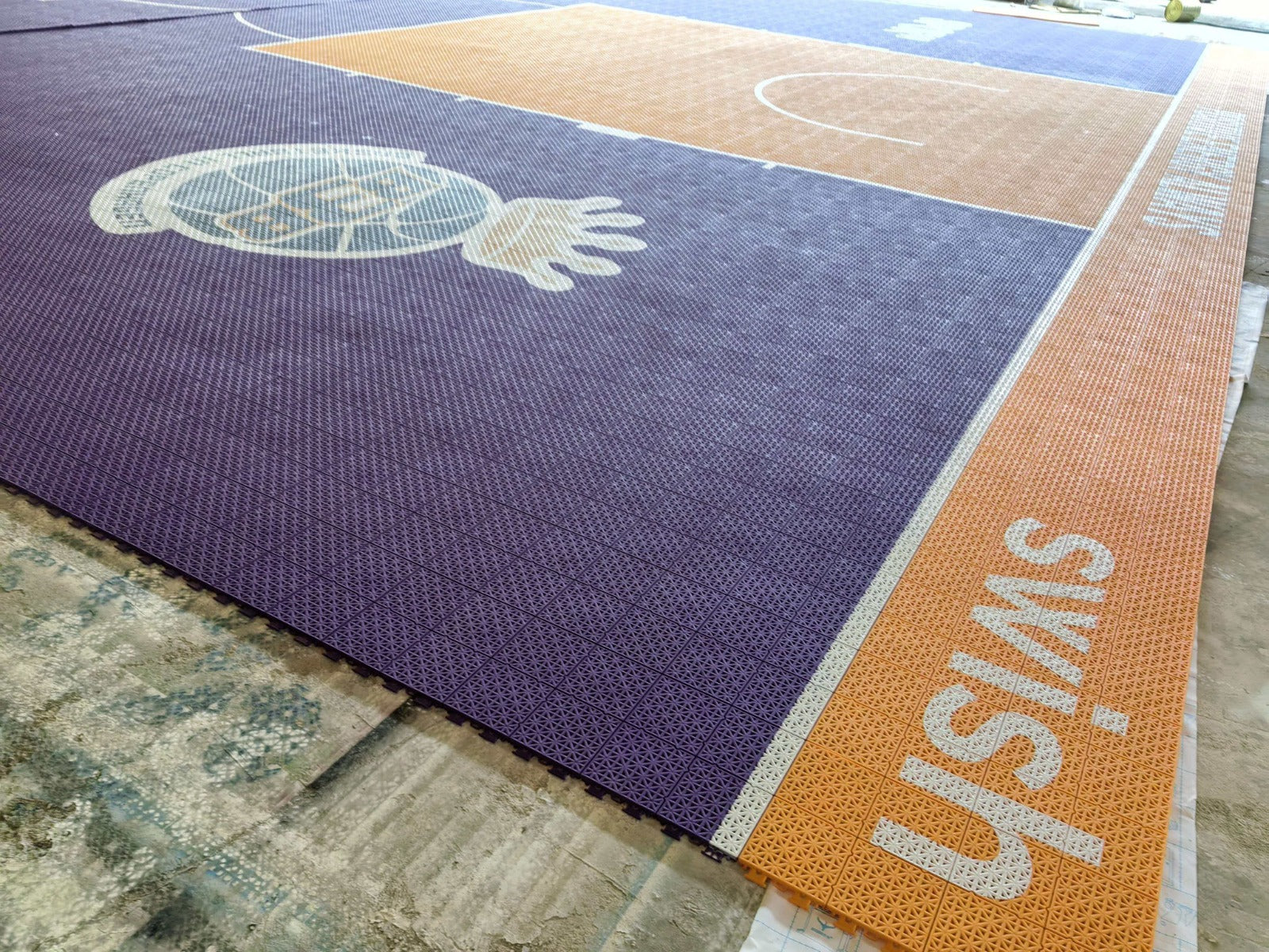 Wide warehouse view of the B3B purple and orange basketball court