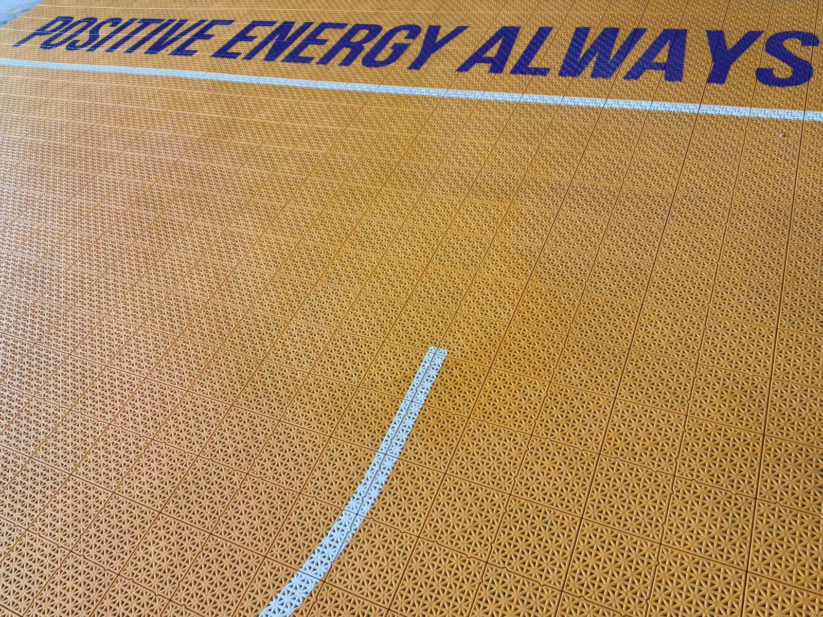 Positive Energy Always border artwork on the orange B3B court tiles