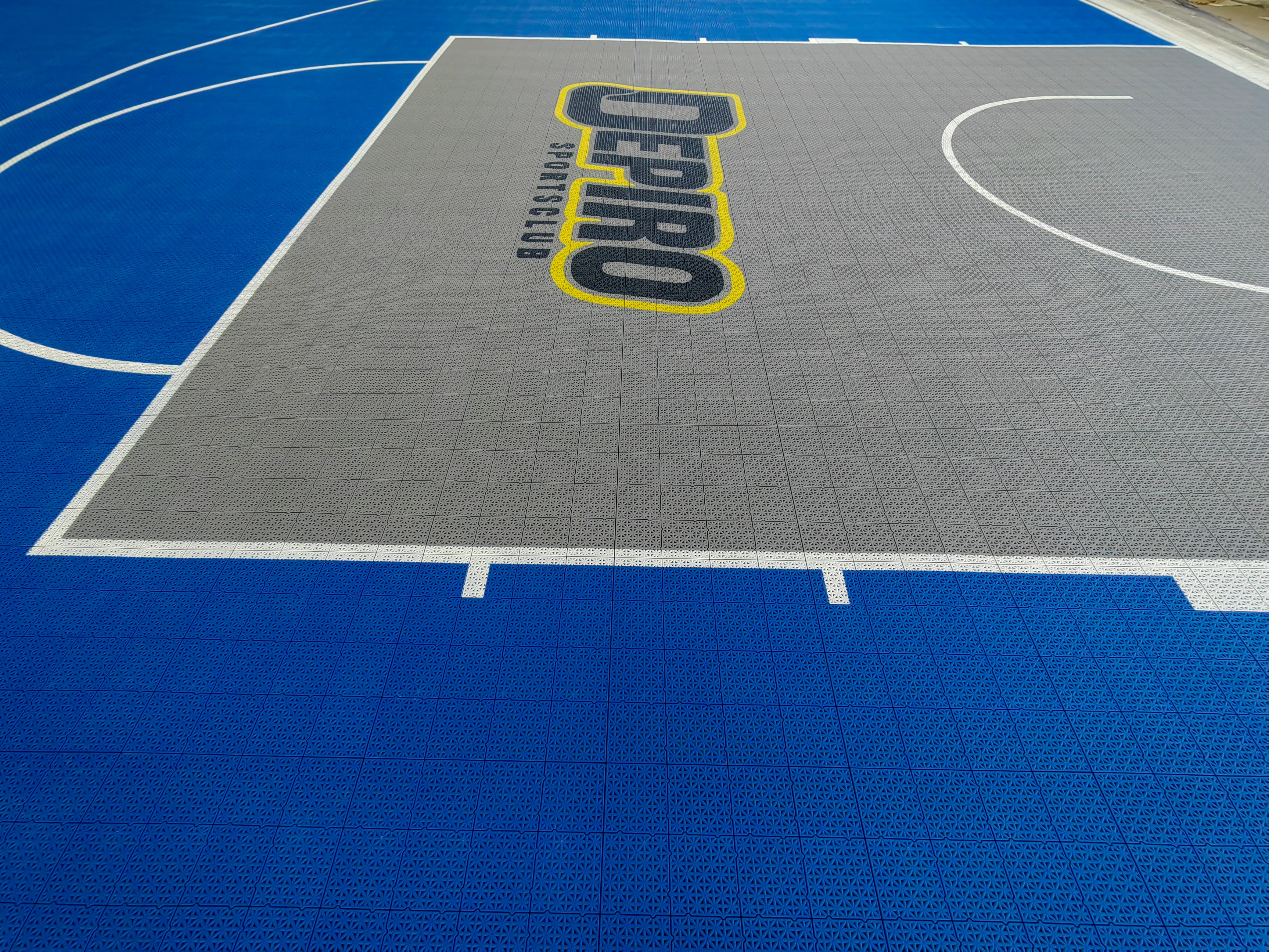 Gray key, white basketball lines, and Depiro branding on modular sports tiles