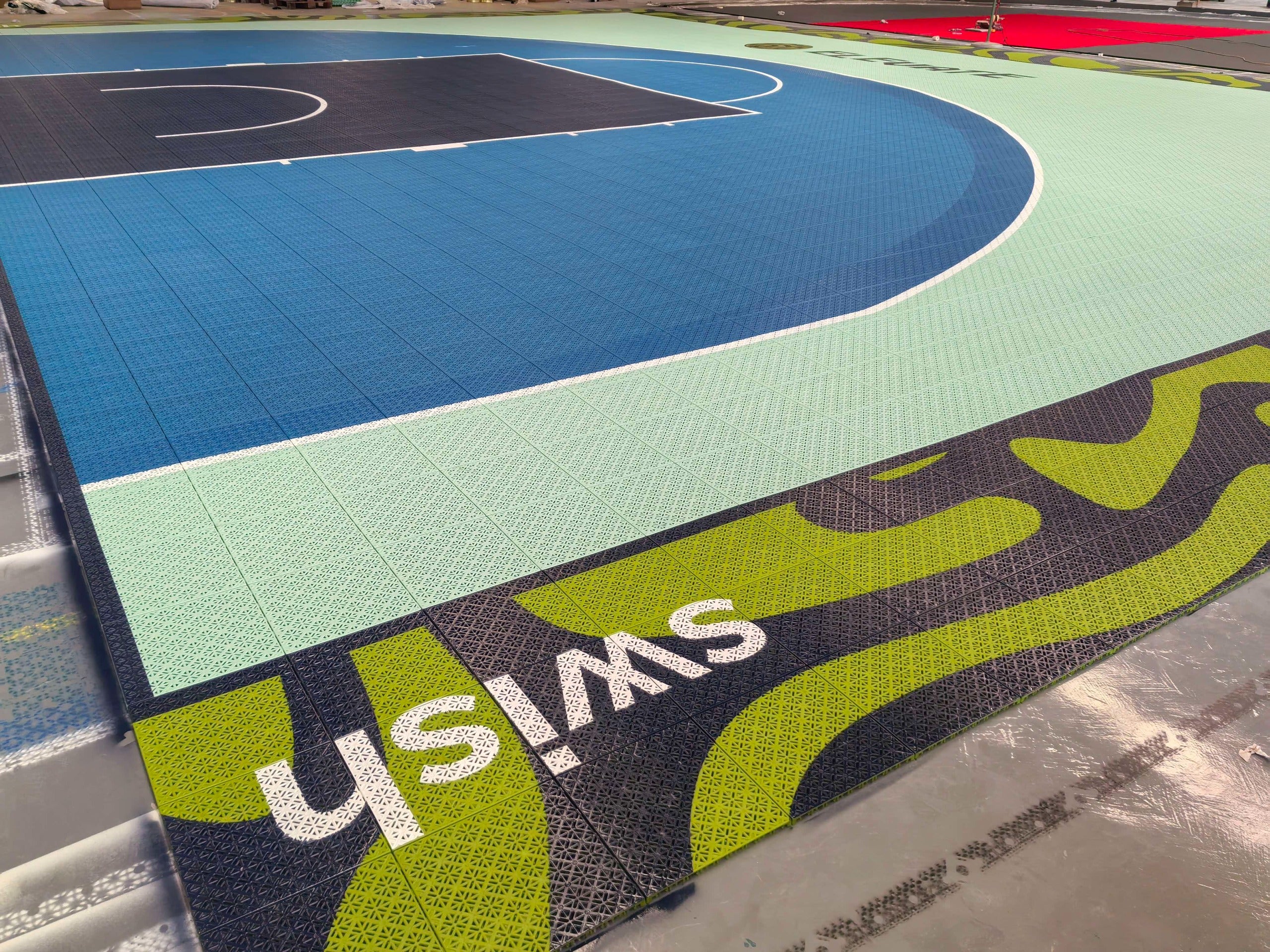 Wide warehouse view of the blue and mint Elevate one-hoop basketball court