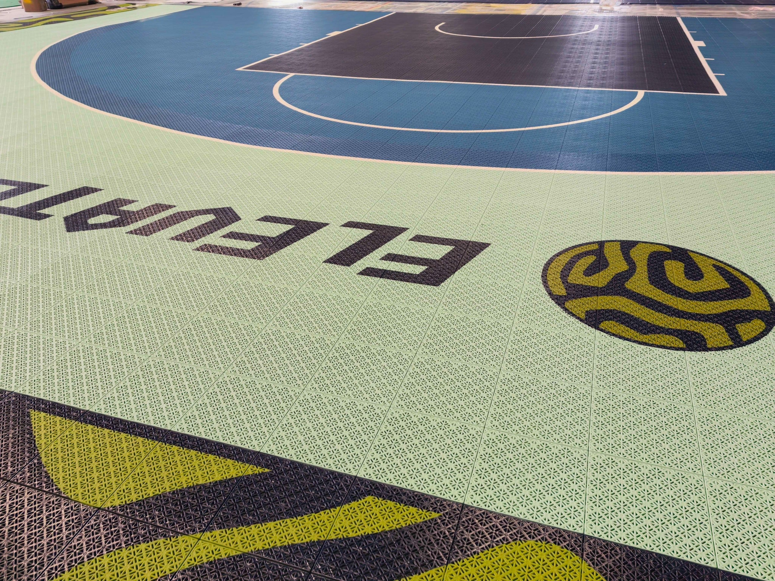Close warehouse view of Elevate branding beside the blue playing area