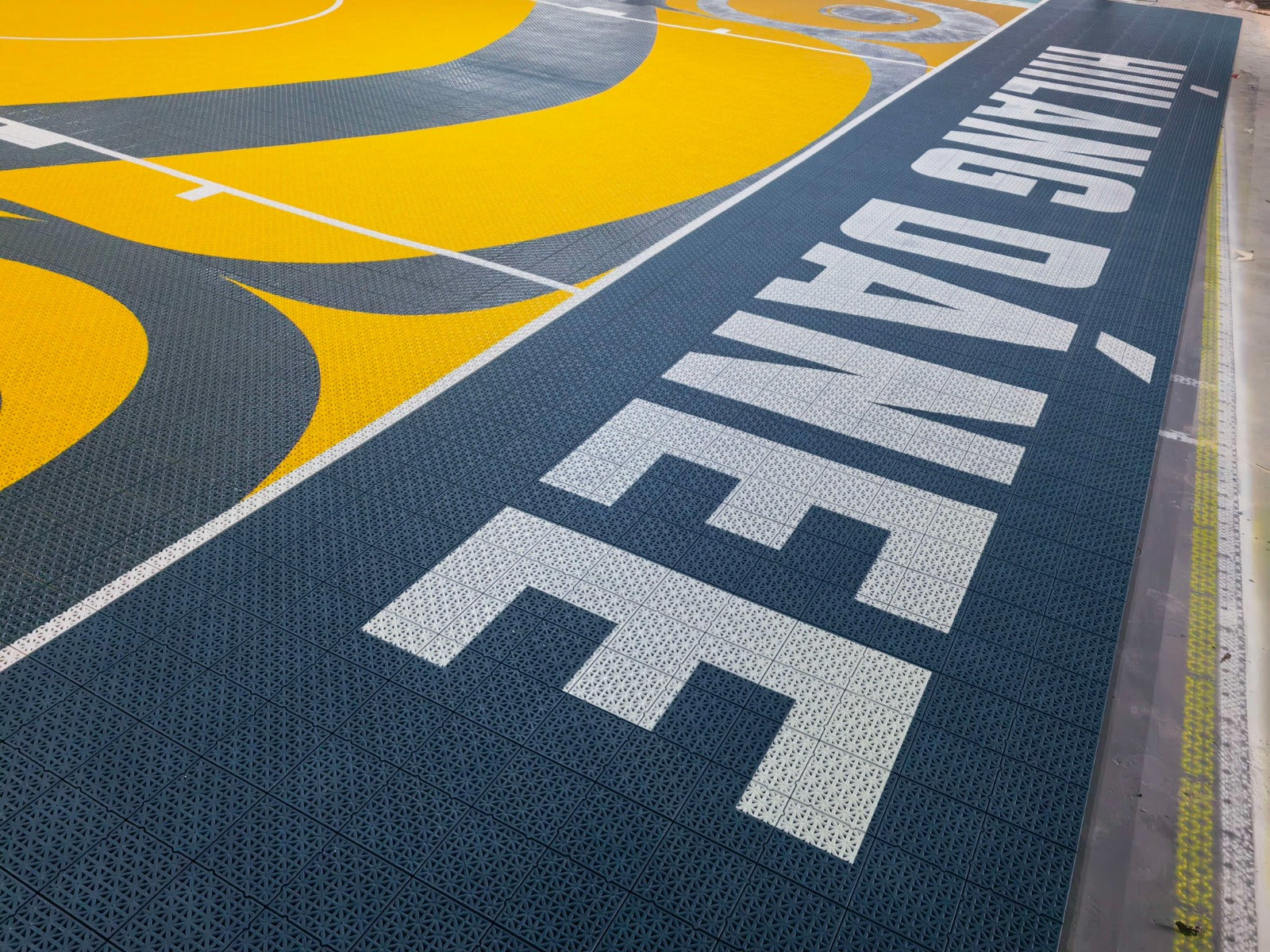 Close view of Híílang Dánee border text and yellow court artwork