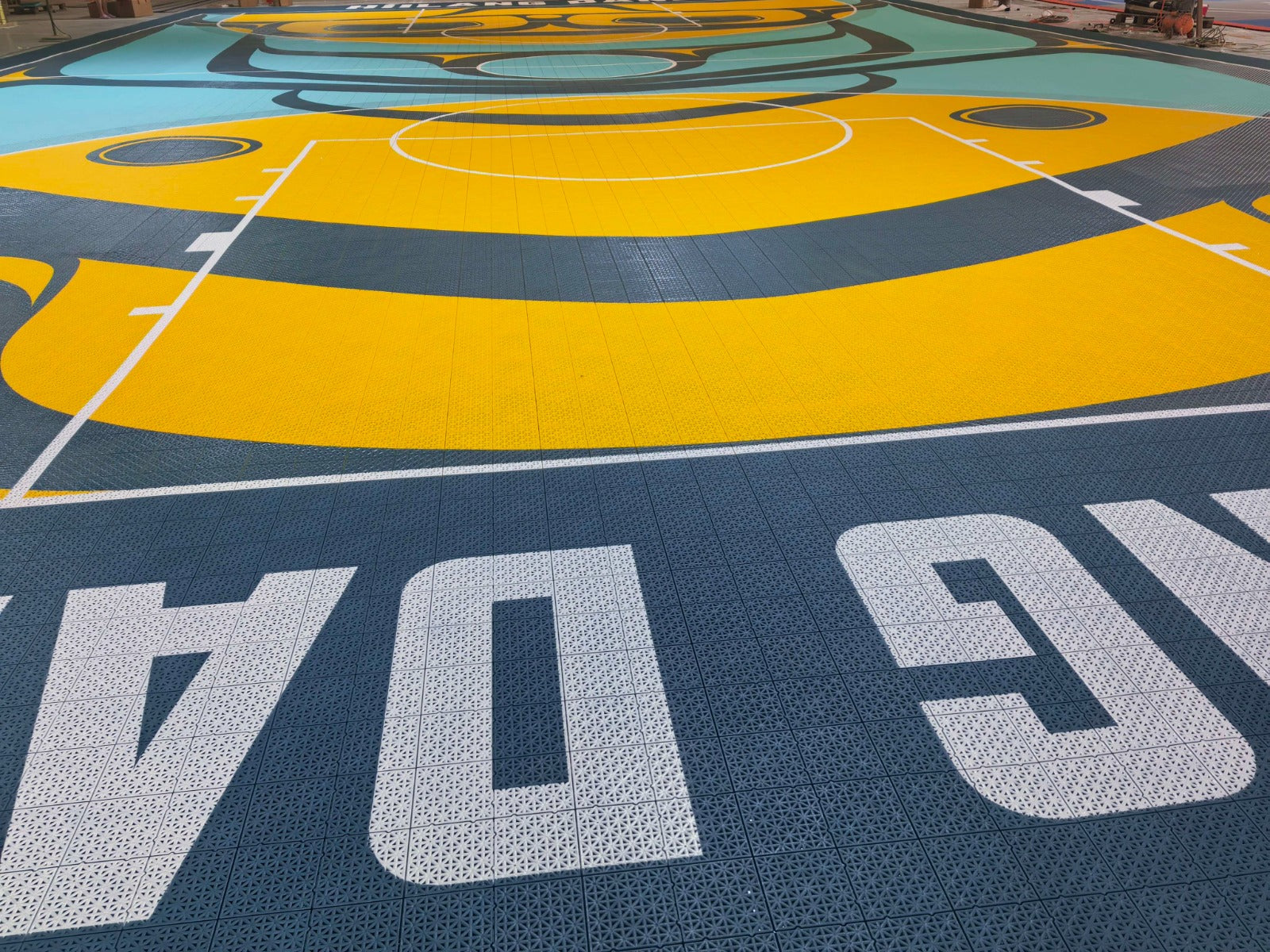 Híílang Dánee court baseline, yellow playing area, and custom graphics