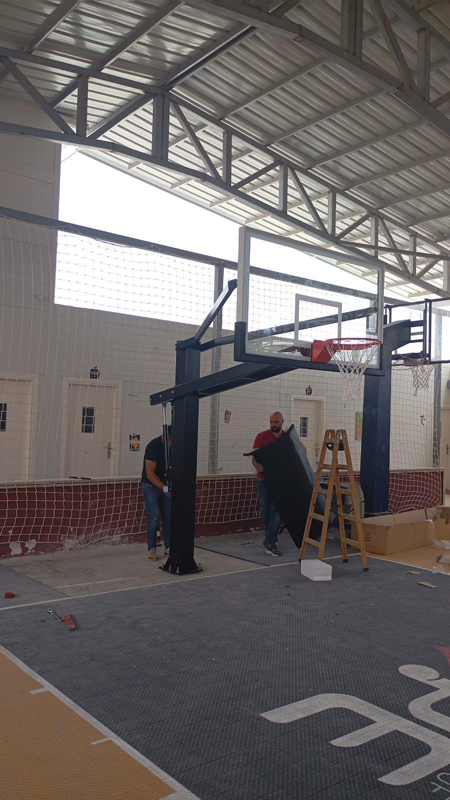 Basketball hoop installation on the Seeds of Hope indoor court
