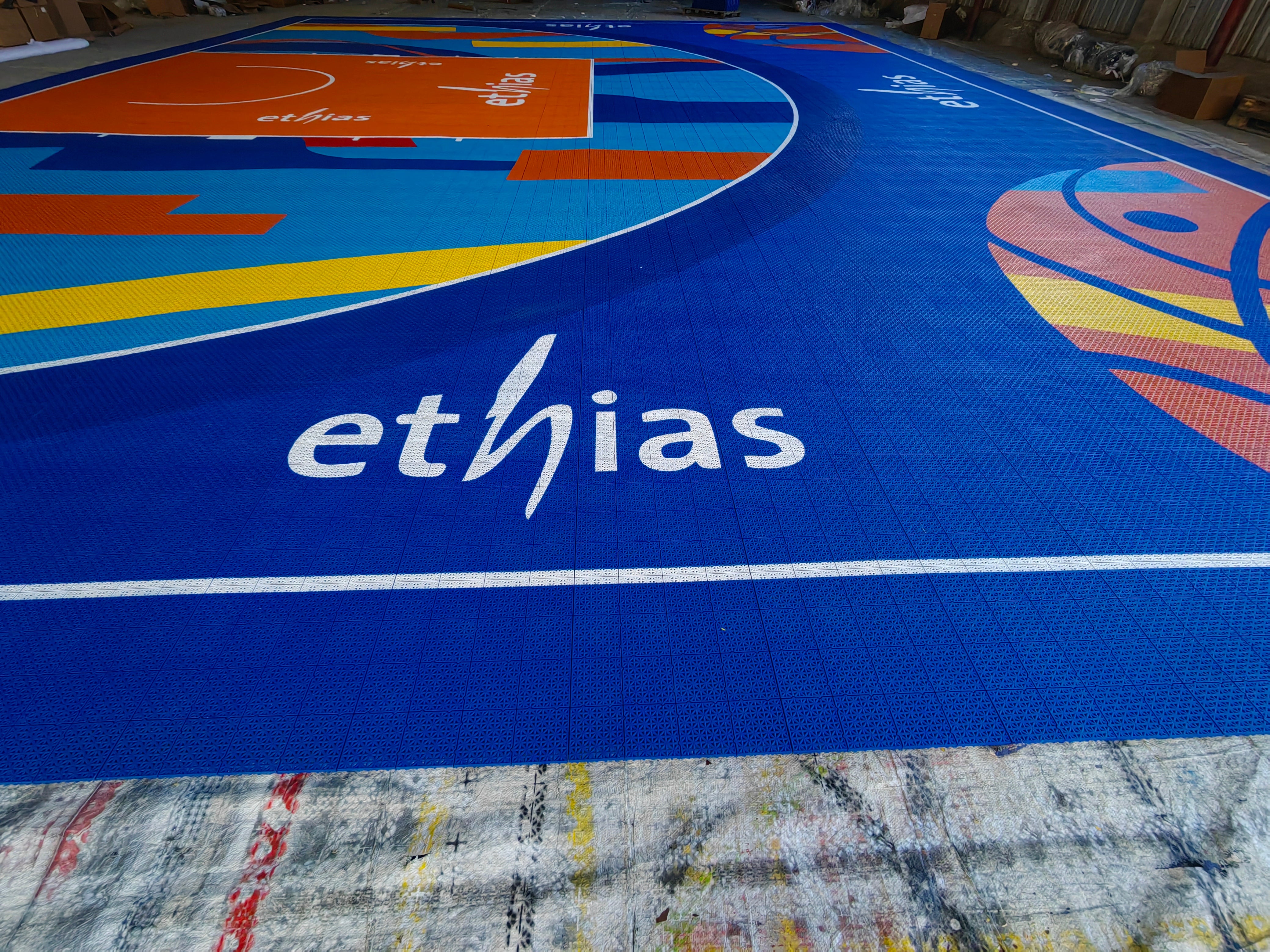 Close warehouse view of the Ethias wordmark and printed modular tiles